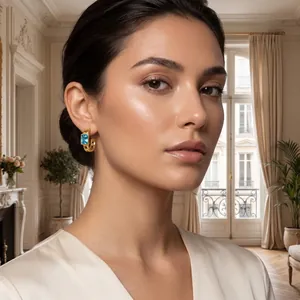 Elegant close-up view of a gold rectangle blue zircon hoop earring on a model's ear