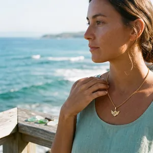Élégant collier avec pendentif ange en or porté par une femme sur fond d'océan panoramique