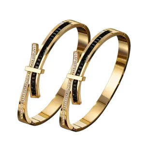 Elegant gold-plated stainless steel bow bangle with black and white crystals