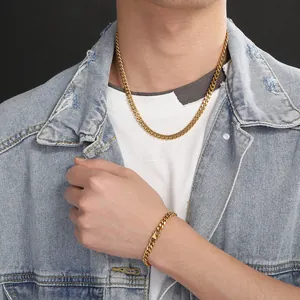 Golden stainless steel Cuban link necklace and bracelet worn by model with denim jacket.