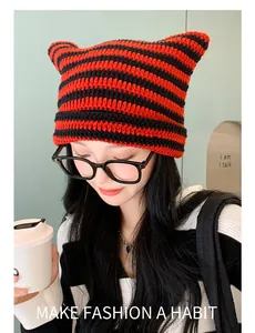 Asian girl wearing a red and black striped hand-knitted cat ear hat with glasses