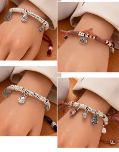 Close-up of hand-woven rope bracelets with silver charms and fortune cat pendants