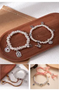 Detailed view of handmade broken silver bracelets featuring traditional Chinese charms and ropes