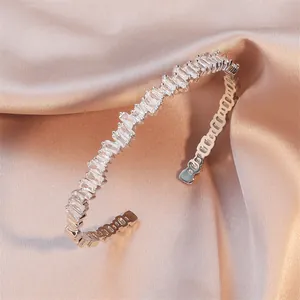 Geometric irregular baguette zircon cuff bracelet in silver finish on luxury pink silk.