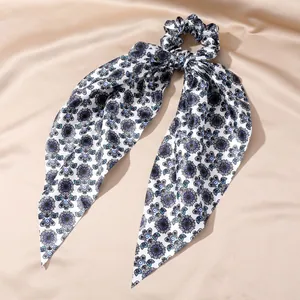 Elegant vintage silk hair scrunchie featuring a blue evil eye print and long scarf ribbon