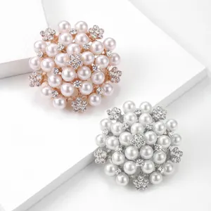 Broche élégante en perles et strass au design de fleur, finitions or rose et argent.