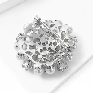 Vue arrière détaillée d'une élégante broche en perles argentées avec fermoir à épingle.
