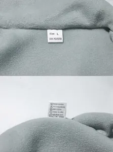 Detailed macro view showing the wash label and grey polar fleece texture of the men's jacket