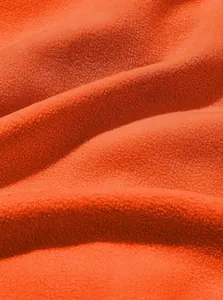 Close-up macro view of soft orange polar fleece fabric showing texture and ripples.