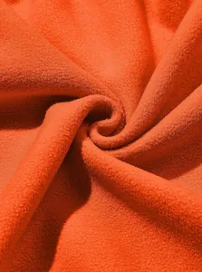 High-quality macro detail showing the soft texture of vibrant orange polar fleece fabric
