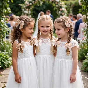 Eleganti grandi fiocchi per capelli in nastro con perle su damigelle.