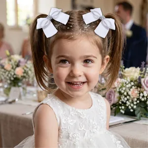 Eleganti fiocchi per capelli in nastro bianco con strass indossati da una bimba sorridente