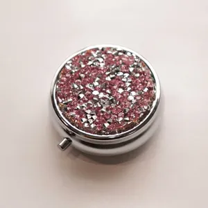 Portable round metal pill box encrusted with sparkling pink and silver rhinestones