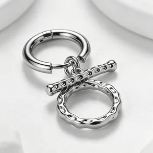 Close-up detail of silver stainless steel OT toggle earrings with textured hammered finish