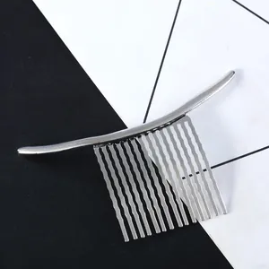 Vue détaillée d'un peigne à cheveux en métal argenté minimaliste avec dents ondulées et fini lisse.