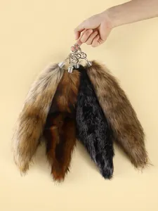 Detailed view of four large colorful faux fur fox tail keychains for bags and cars