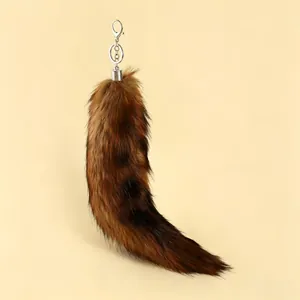 Detailed view of a large fluffy brown fox tail fur keychain with silver clip.