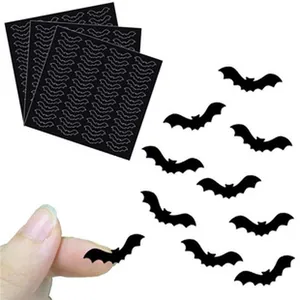 Close-up of small black bat sticker for size reference with multiple sticker sheets