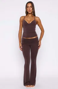 Full body view of model wearing a dark brown V-neck camisole top and matching flare pants