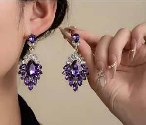 Close-up detail of luxury vintage purple crystal cluster earrings worn on model ear