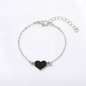 Bracciale minimalista a catena d'argento con ciondolo a cuore in smalto nero e chiusura regolabile.