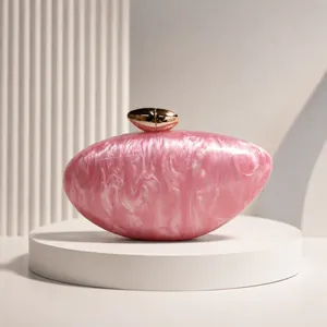 Close-up of pink marble acrylic material and gold bullet clasp on evening clutch