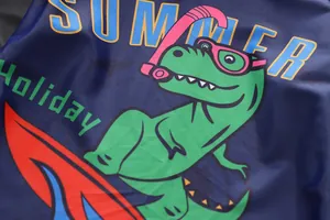 Gros plan d'un imprimé dinosaure surfant mignon sur un maillot de bain bleu