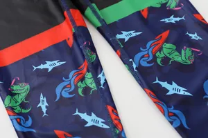 Zoom sur le tissu de maillot de bain pour garçons avec motifs de dinosaures et requins