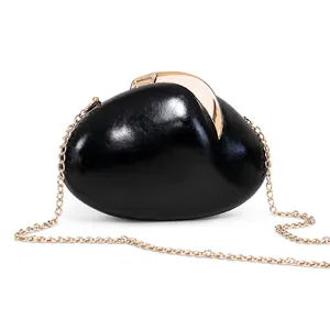 Detailed view of a glossy black pebble-shaped evening clutch bag with gold chain