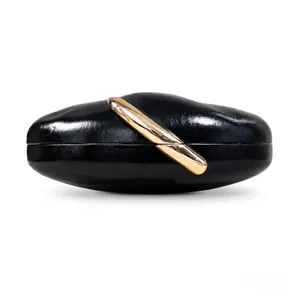 Close-up of black PU leather evening clutch with gold diagonal metal handle
