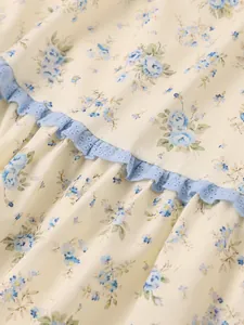 Close-up detail of vintage floral print fabric with delicate light blue ruffle lace trim.