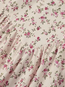 Close-up of pink floral print fabric with delicate pleated ruffles for summer dress