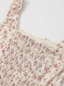 Detailed view of floral print smocking and lace trim on a French style summer dress