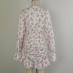 Vue arrière d'une mini robe fleurie blanche avec taille froncée et poignets à volants