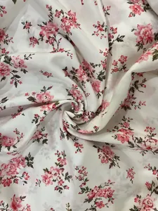 Vue détaillée d'un motif floral rose élégant sur un tissu blanc doux et léger