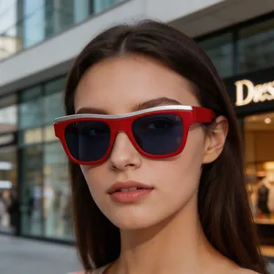 Detailed close-up of stylish red frame sunglasses with silver top bar worn by a female model outdoors