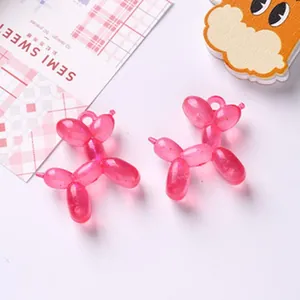 Dettaglio di ciondoli a forma di cane palloncino in acrilico rosa glitterato per gioielli DIY