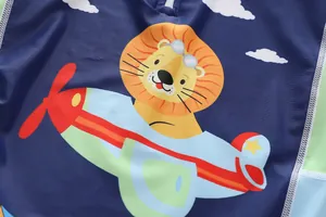 Detailaufnahme eines Cartoon-Löwen-Piloten-Prints auf einem dunkelblauen Kinderbadeanzug