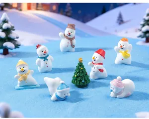 Macro view of miniature resin snowmen and Christmas tree figurines on blue snow