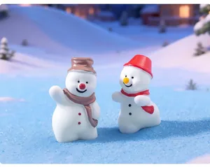Detailed macro view of two cute miniature Christmas snowman figurines in a snowy winter scene