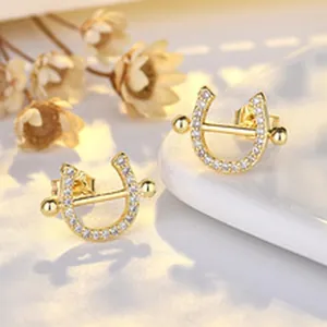 Close-up of elegant gold-plated horseshoe earrings with pave-set sparkling stones