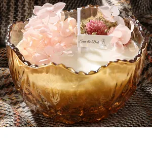 Close-up of scented candle in amber glass bowl with pink flowers