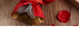 Close-up of elegant red gift packaging featuring a gold-lined wrap and ETERNAL ribbon detail