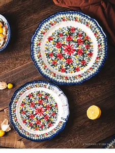 Detail view of 8 and 11 inch exotic daisy retro ceramic deep plates on wood table.