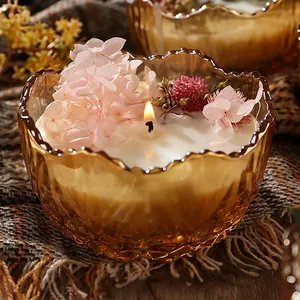 Scented candle in amber glass bowl decorated with dried pink hydrangea flowers