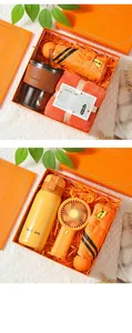Detailed view of corporate gift box set with orange umbrella, thermos, and mini fan
