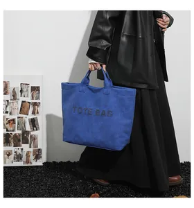 Stylish blue DuPont paper large capacity tote bag featuring studded TOTE BAG text