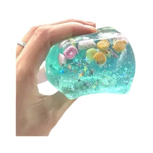 Transparent blue squishy ice cube stress relief toy with sea shells and star glitter