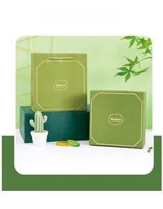 Close-up of elegant green souvenir gift boxes with 'Good Luck' gold foil print