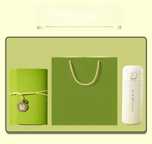 Corporate souvenir gift set featuring a green notebook, white thermos, and a matching paper bag